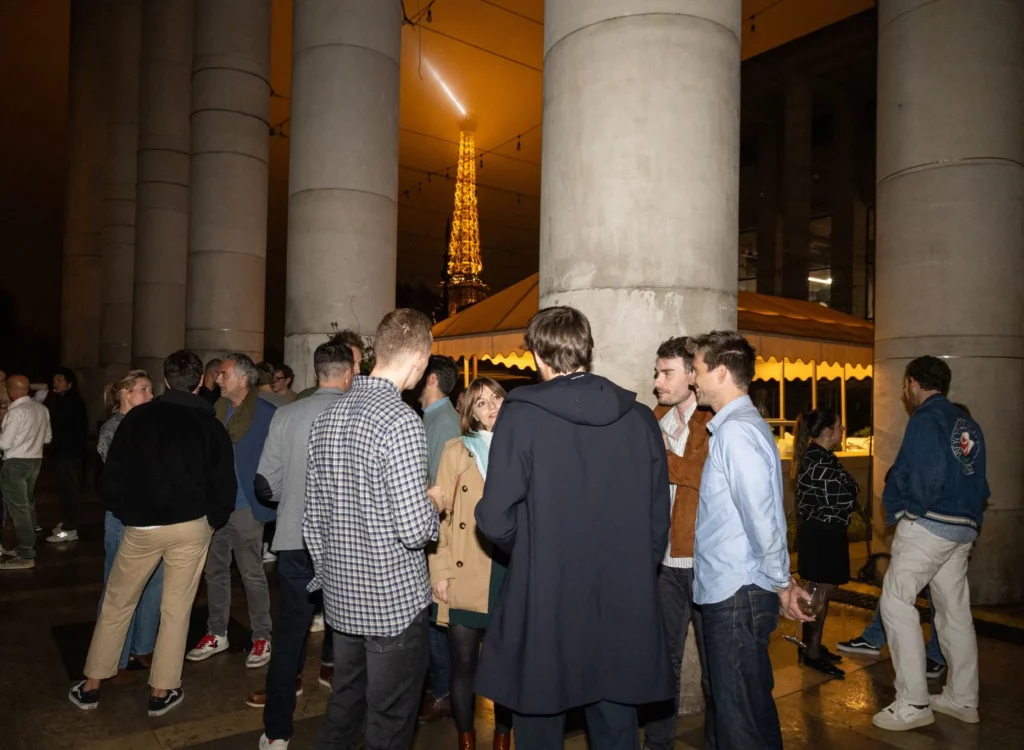 Photo d'un groupe de personnes discutant, la Tour Eiffel est visible en fond
