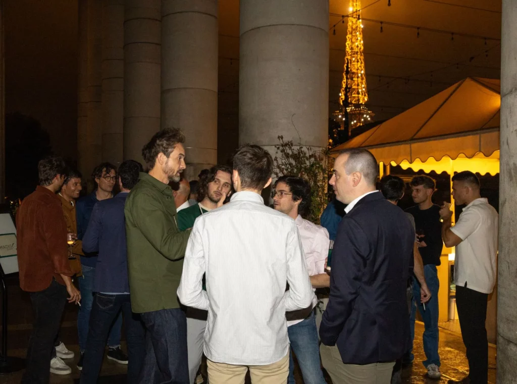Photo d'un groupe de personnes discutant, la Tour Eiffel est visible en fond