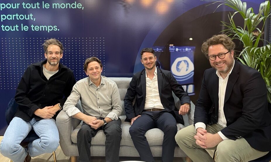 Quatre hommes d'affaires assis sur un canap&eacute;, regard et sourire face cam&eacute;ra