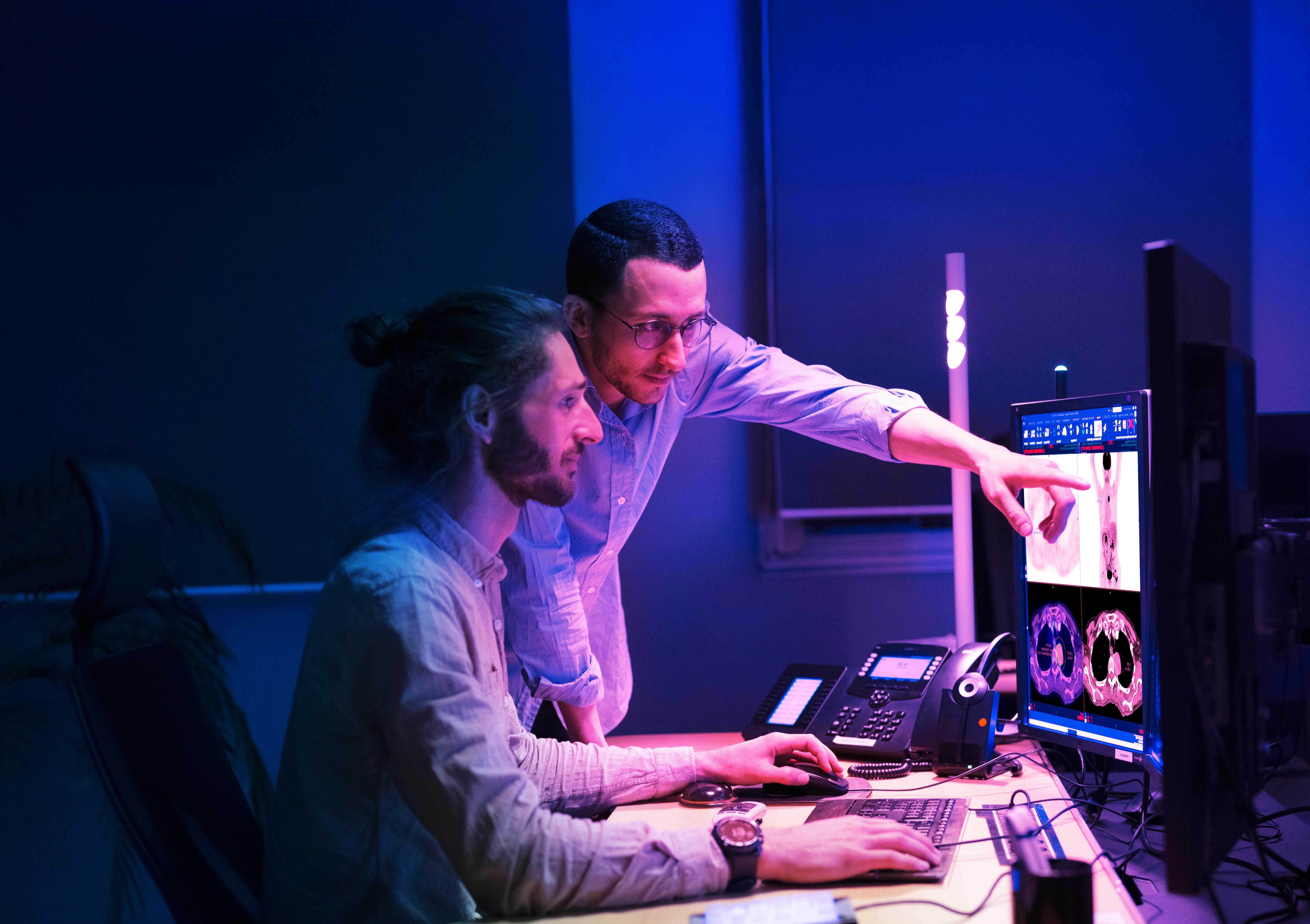 Deux médecins devant des écrans d'ordinateur en train d'interpréter un examen MN